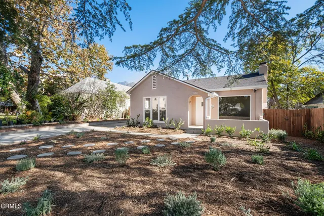 a front view of a house with a garden and yard