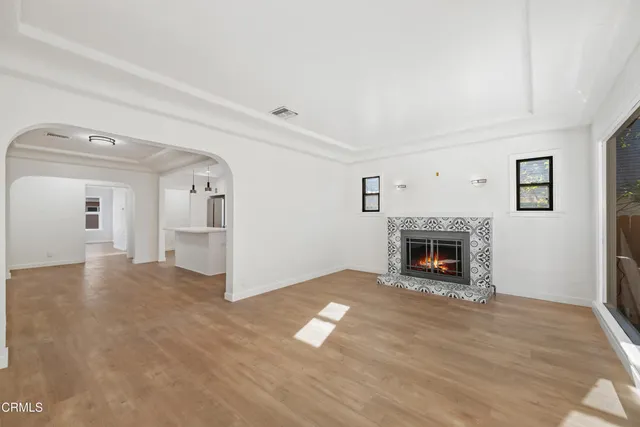 a view of empty room with fireplace and wooden floor