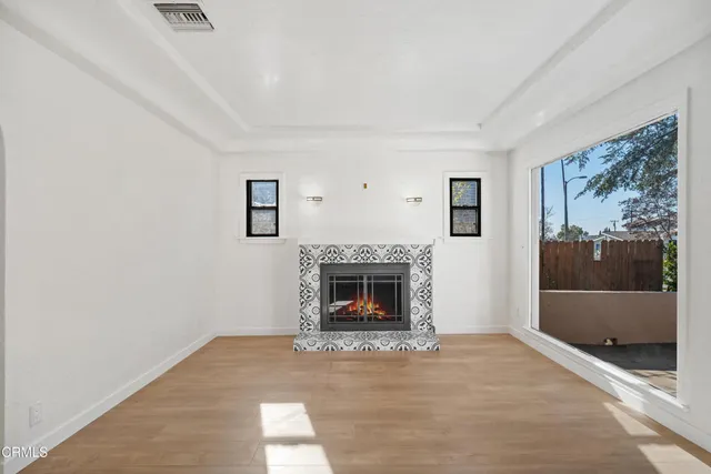 a living room with a fireplace and a floor to ceiling window