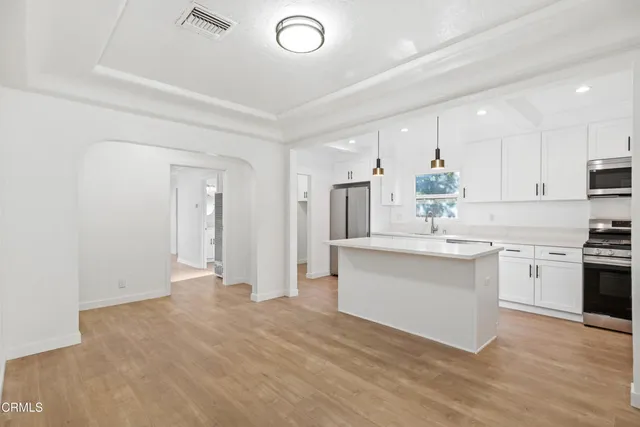 a kitchen with white cabinets and appliances