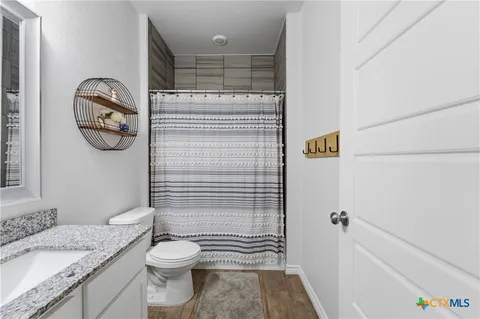 a bathroom with a granite countertop toilet and a sink