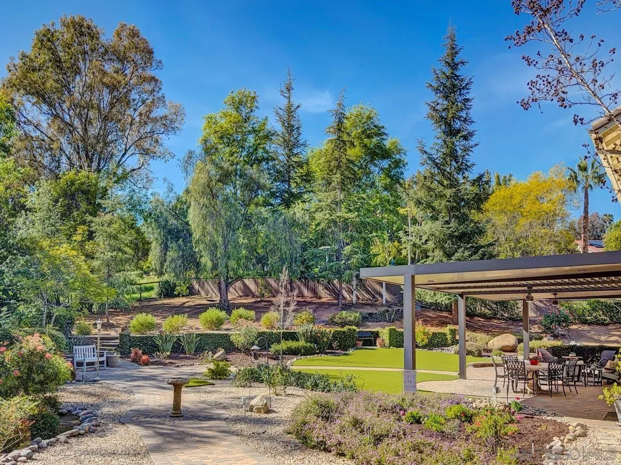 14922 Derringer Road Poway, CA 92064 - Photo 50 of 66 a view of a patio with table and chairs potted plants and large tree