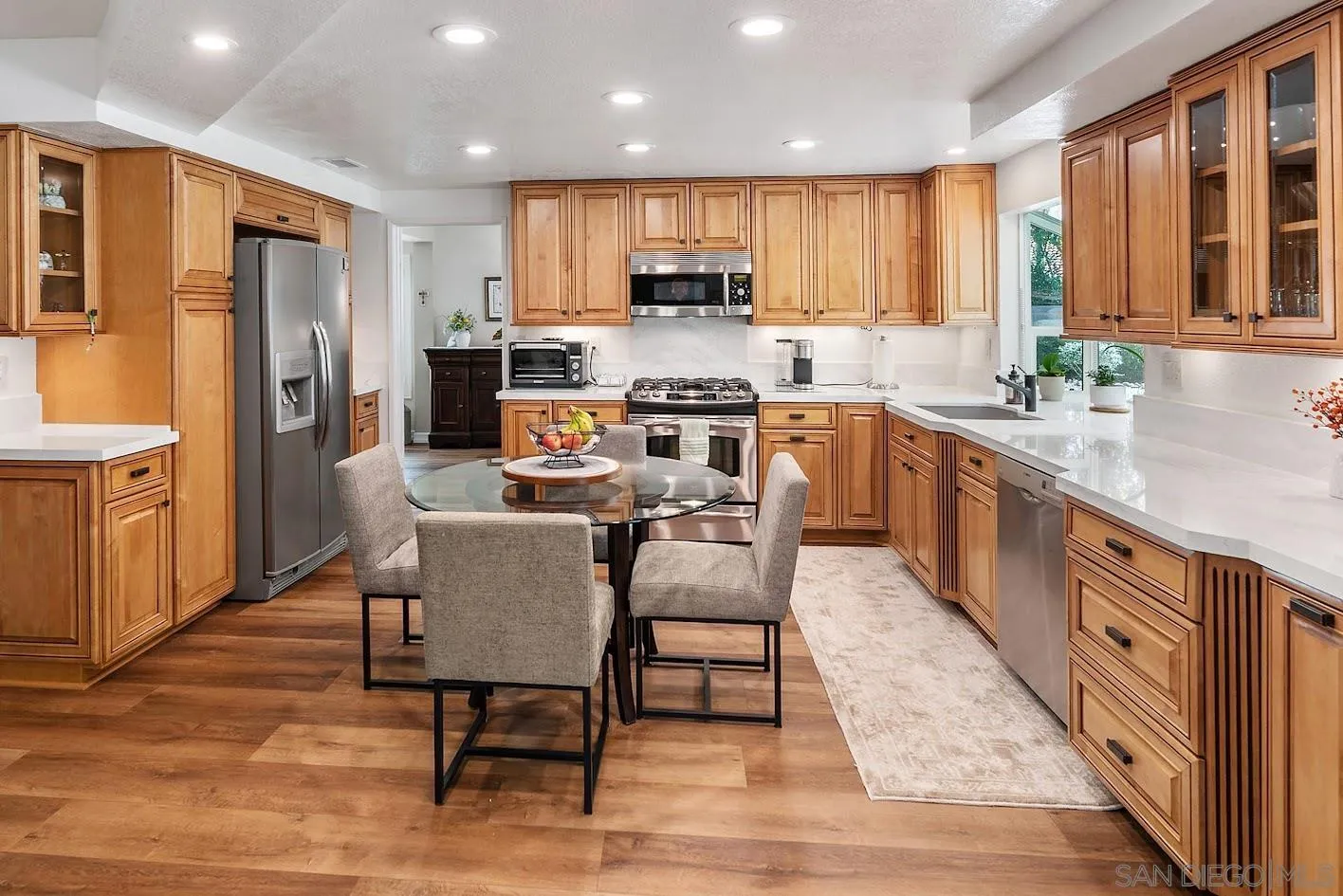 14922 Derringer Road Poway, CA 92064 - Photo 7 of 66 a kitchen with stainless steel appliances granite countertop a table chairs sink refrigerator and cabinets