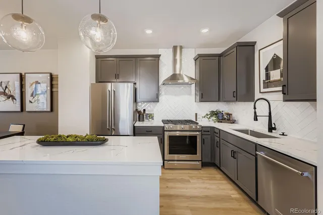 a kitchen with stainless steel appliances granite countertop a sink stove and refrigerator