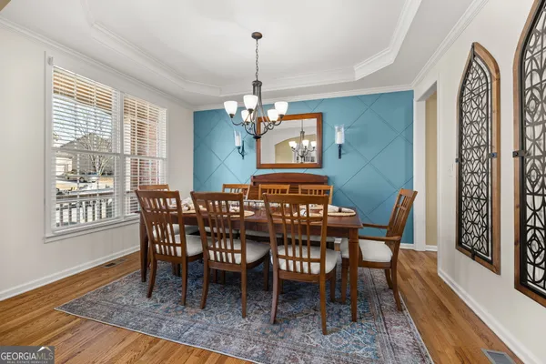 a view of a dining room with furniture wooden floor and chandelier