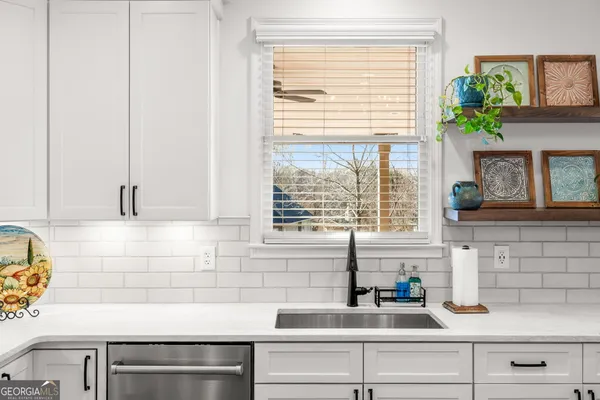 a view of a living room with a chandelier fan and a window