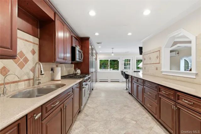 a large kitchen with stainless steel appliances granite countertop a sink and cabinets