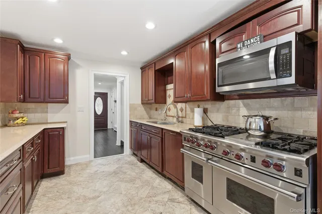a kitchen with stainless steel appliances granite countertop a stove top oven microwave and refrigerator