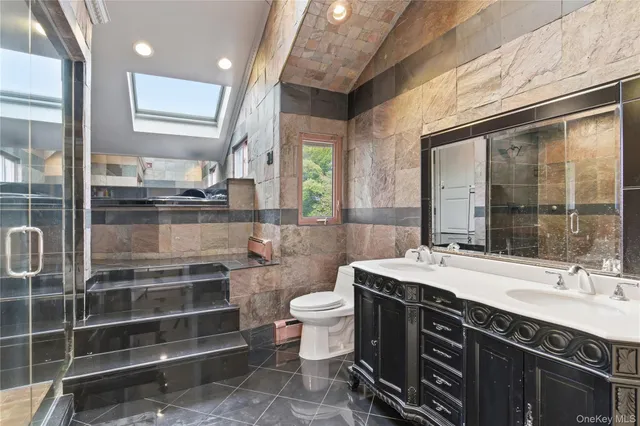 a bathroom with a double vanity sink a toilet and a shower