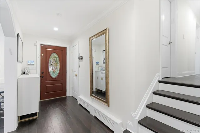 a view of an entryway with wooden floor and mirror