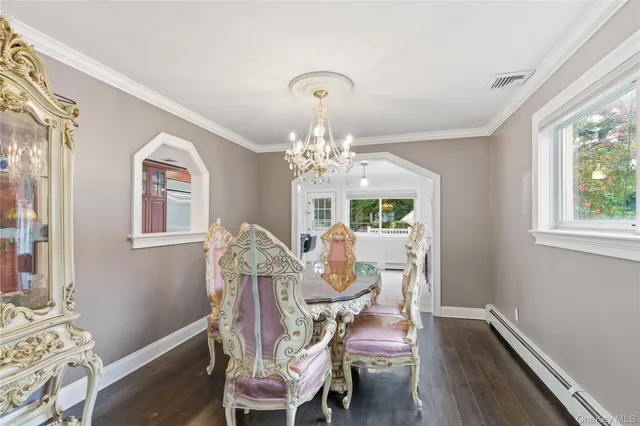 a view of a dining room with furniture a chandelier and wooden floor