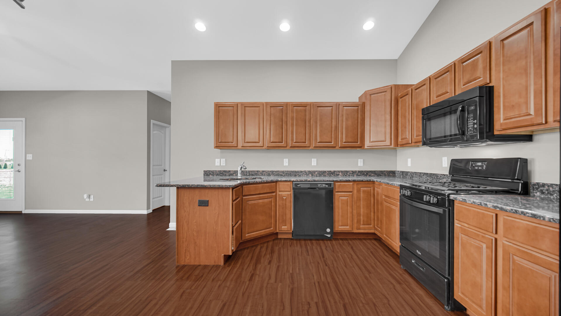 3889-91 Stadium Street Portage, IN 46368 - Photo 9 of 23 a kitchen with stainless steel appliances granite countertop wooden cabinets a stove a sink and a wooden floor