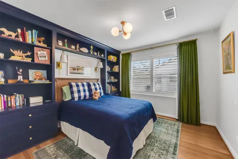 a bedroom with a bed dresser and a window