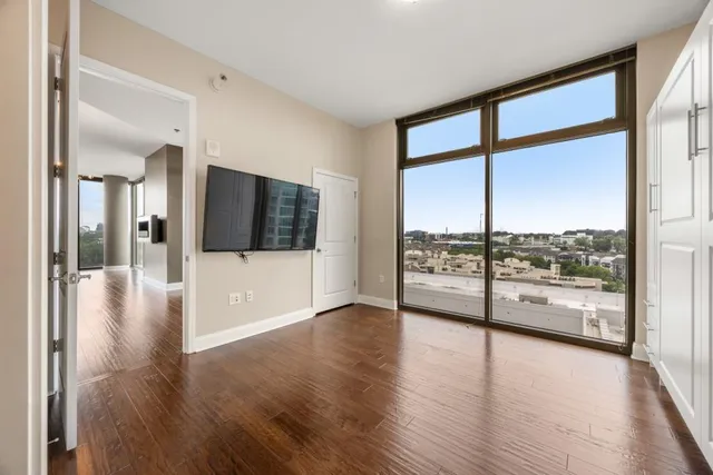 an empty room with wooden floor and windows