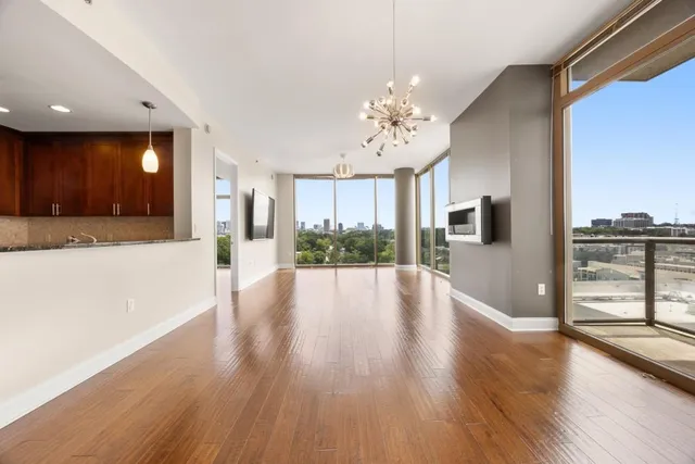 a view of a room with wooden floor and large windows