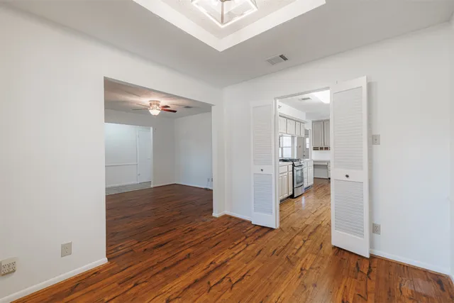 a dining room with furniture a chandelier and wooden floor
