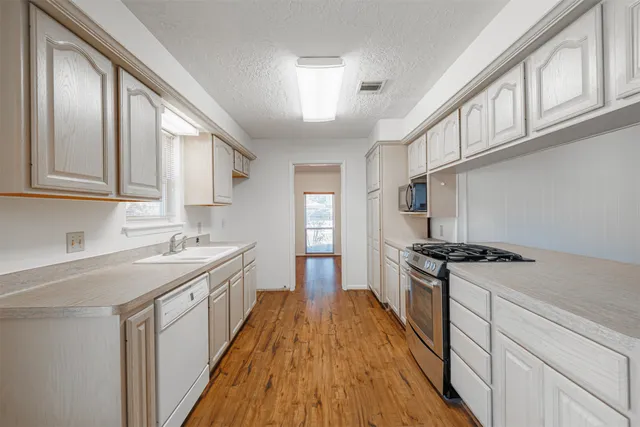 a kitchen with cabinets and wooden floor