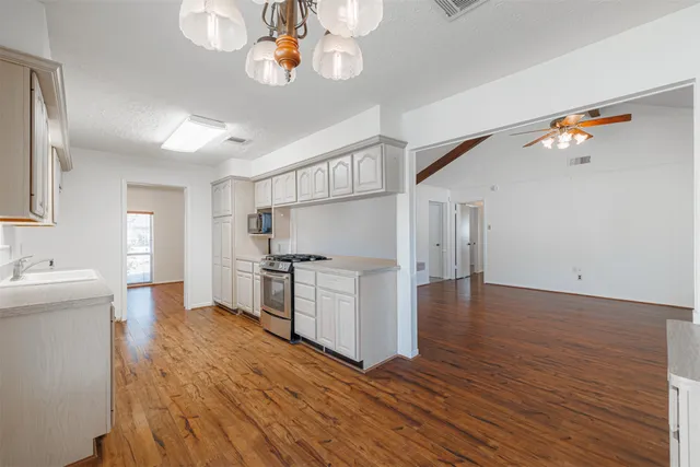 a view of an empty room with wooden floor and a fireplace