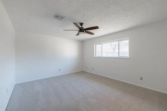 an empty room with closet and windows