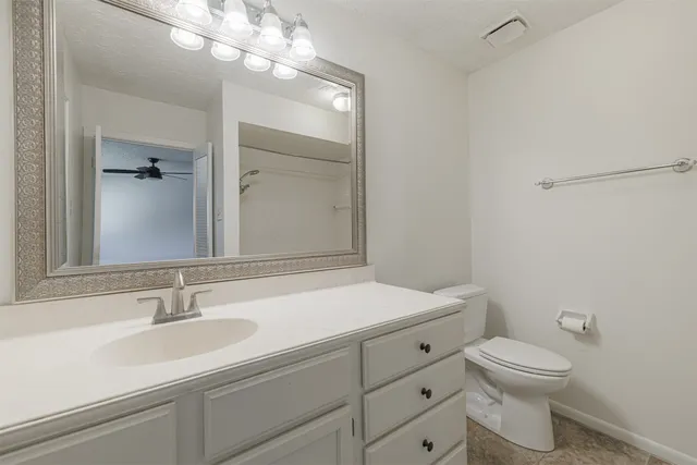 en empty room with windows and ceiling fan