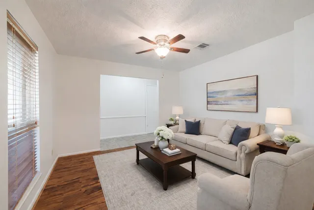 an empty room with wooden floor closet and windows