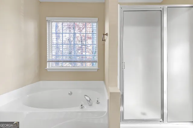 a white bath tub sitting in a bathroom next to a window