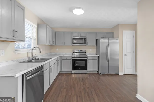 a kitchen with stainless steel appliances a refrigerator sink and cabinets