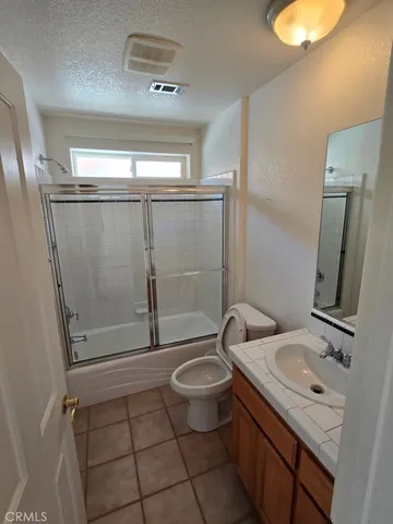 a kitchen with a sink a stove cabinets and wooden floor