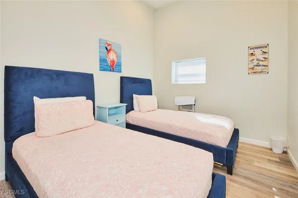 a bedroom with two beds and a wooden floor