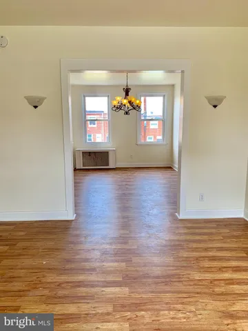 a view of a living room with hardwood floor and windows