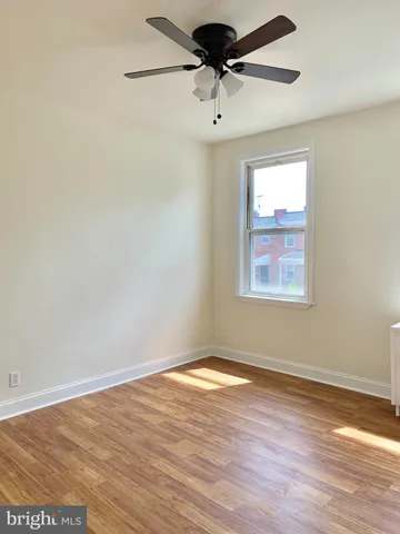 a view of a room with wooden floor and a ceiling fan