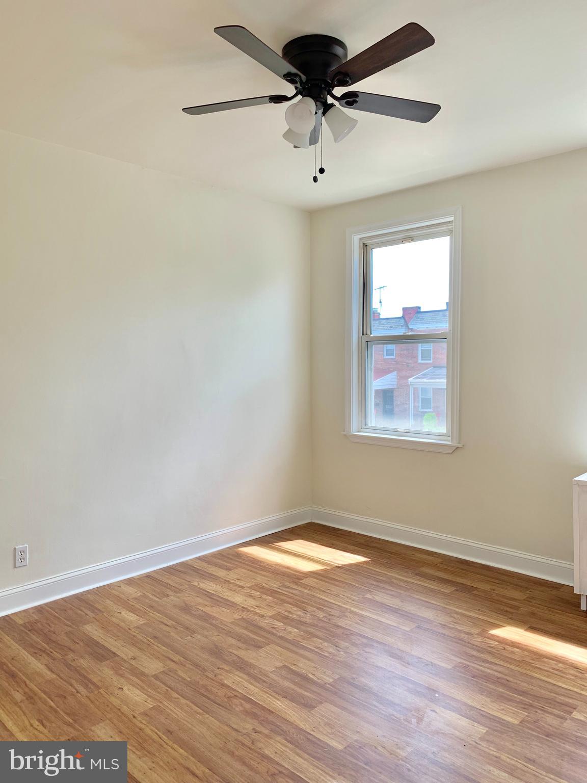 3542 Lyndale Avenue Baltimore, MD 21213 - Photo 9 of 12 a view of a room with wooden floor and a ceiling fan