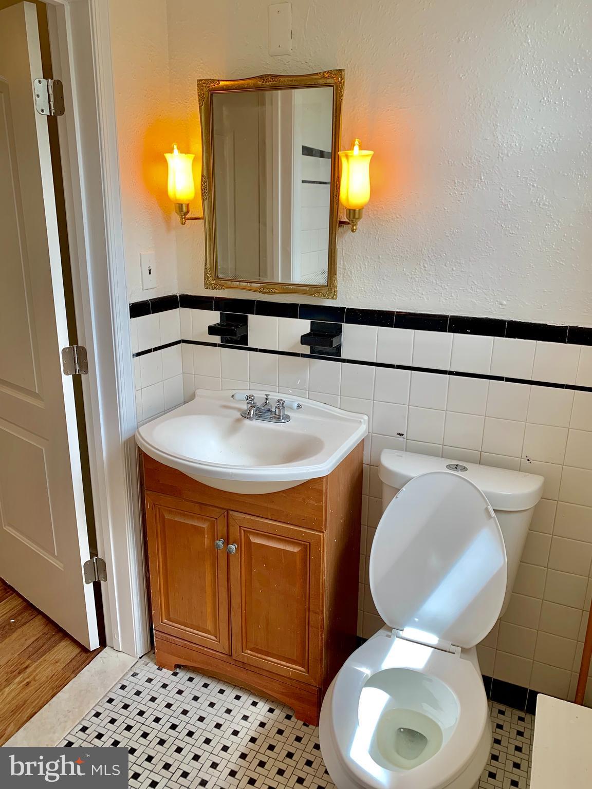 3542 Lyndale Avenue Baltimore, MD 21213 - Photo 10 of 12 a bathroom with a sink a toilet and mirror