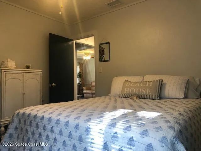 a bedroom with a large bed and painting on the wall