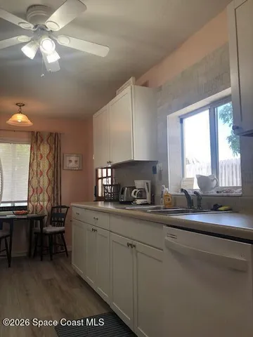 a kitchen with stainless steel appliances a sink a stove a dining table and chairs