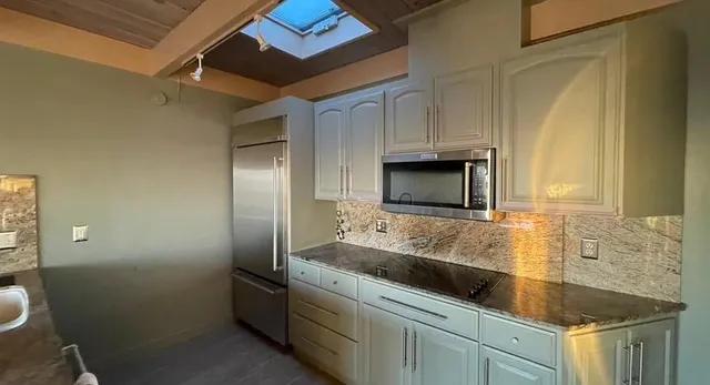 a kitchen with stainless steel appliances granite countertop a sink and a granite counter tops
