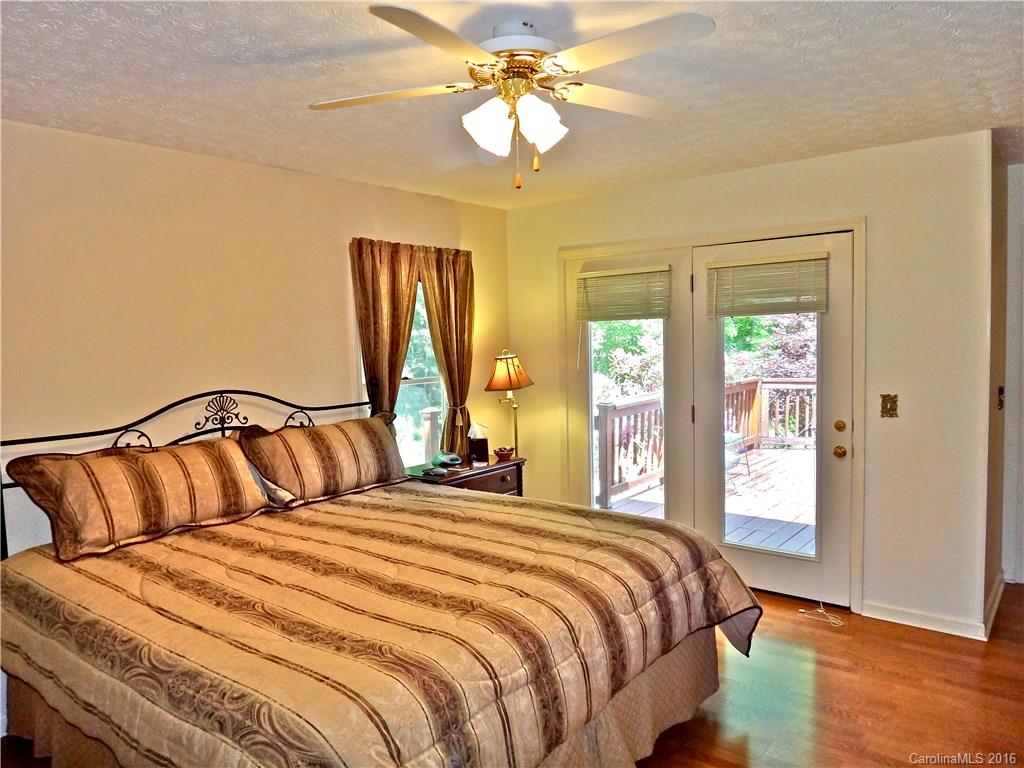 660 Edwards Cove Road, Unit 1 Waynesville, NC 28786 - Photo 11 of 24 a bedroom with a large bed and a chandelier