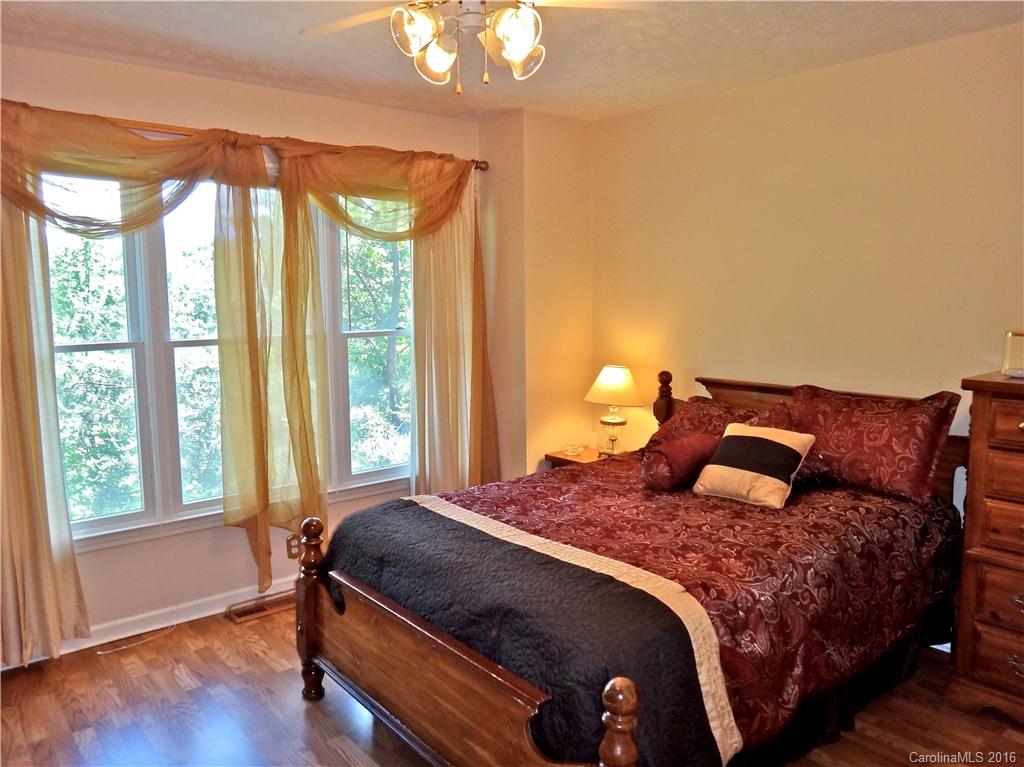 660 Edwards Cove Road, Unit 1 Waynesville, NC 28786 - Photo 14 of 24 a bedroom with a bed and wooden floor