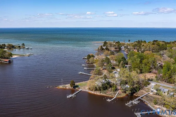 a living room with furniture and a kitchen view with wooden floor