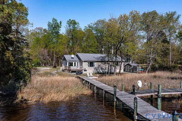 a view of a lake with outdoor seating and yard in the back