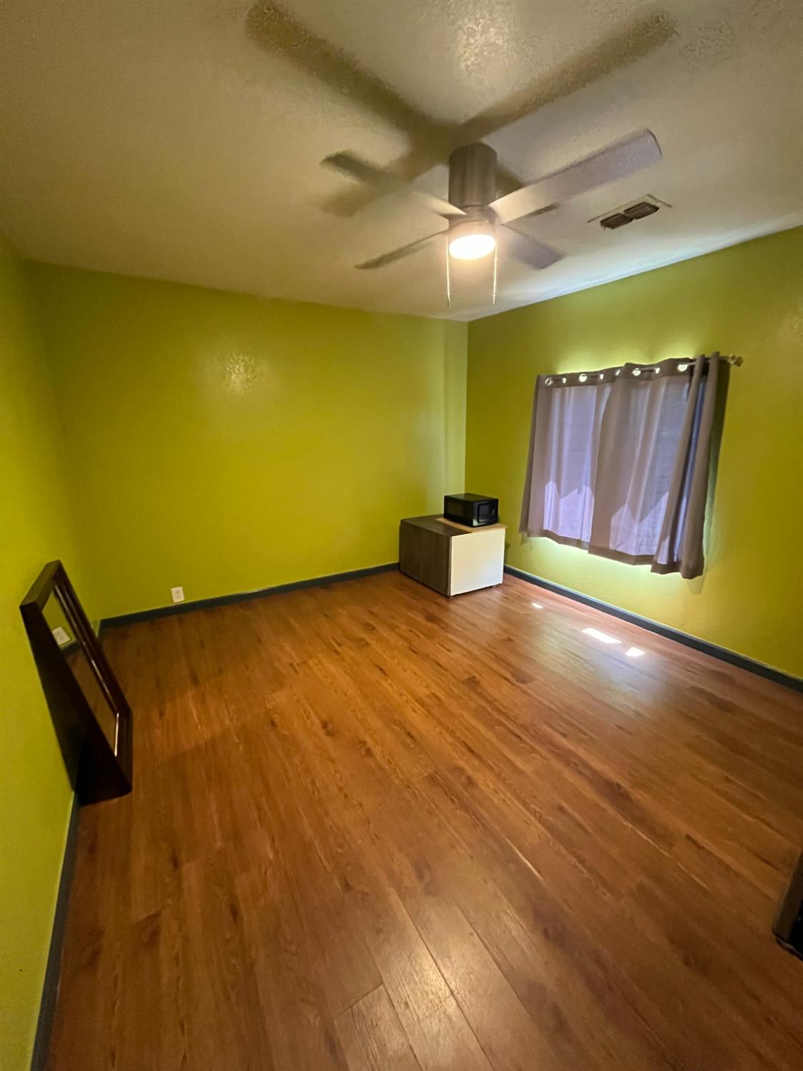 2111 Hackett Road Ceres, CA 95307 - Photo 2 of 9 a view of an empty room with wooden floor