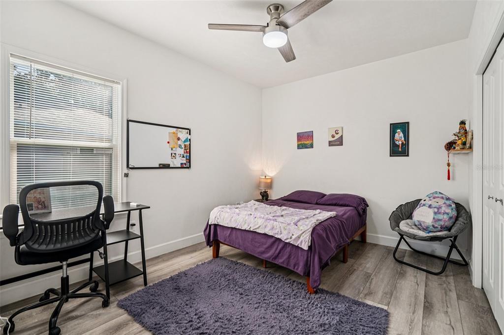 6657 Southwest 15 Place Gainesville, FL 32607 - Photo 13 of 23 a bedroom with a bed a dresser and chair