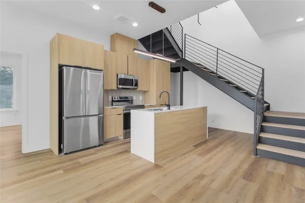 a kitchen with stainless steel appliances a refrigerator and a stove top oven