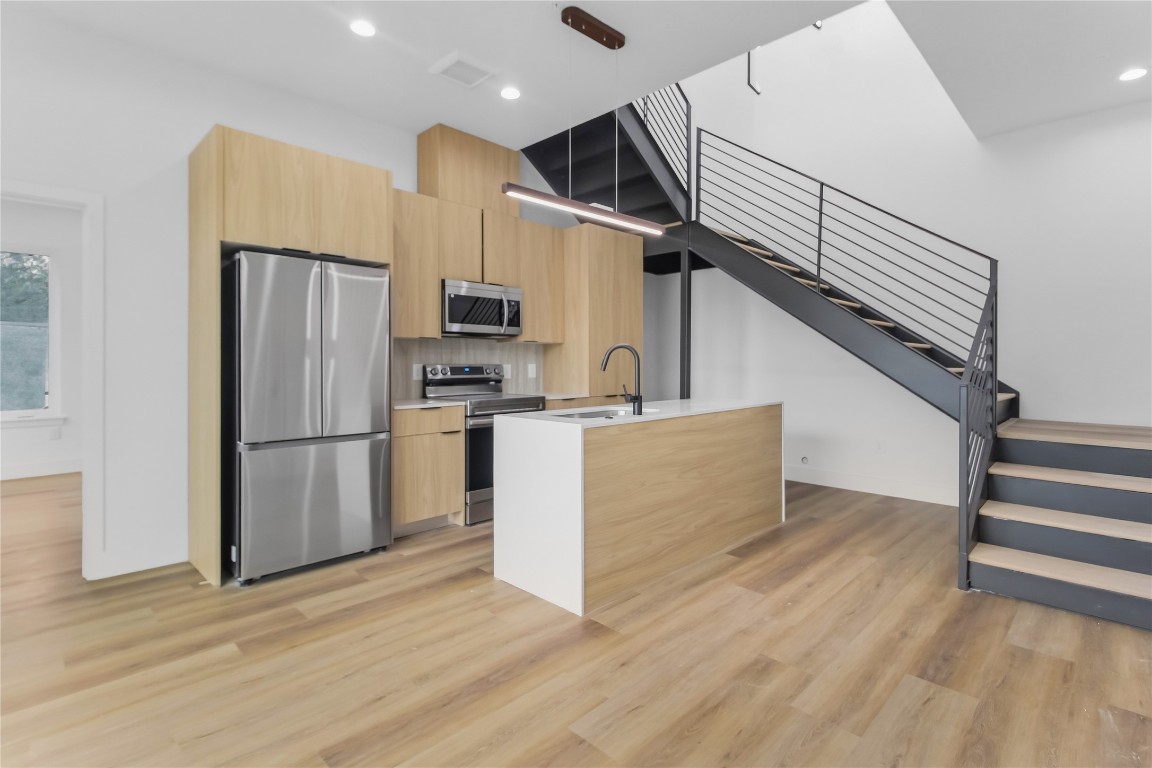 a kitchen with stainless steel appliances a refrigerator and a stove top oven
