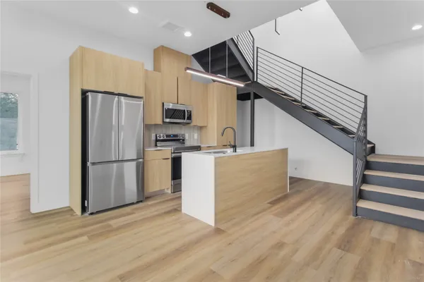 a kitchen with stainless steel appliances a refrigerator and a stove top oven