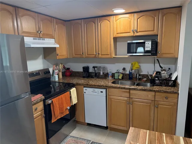 a kitchen with granite countertop white cabinets and stainless steel appliances