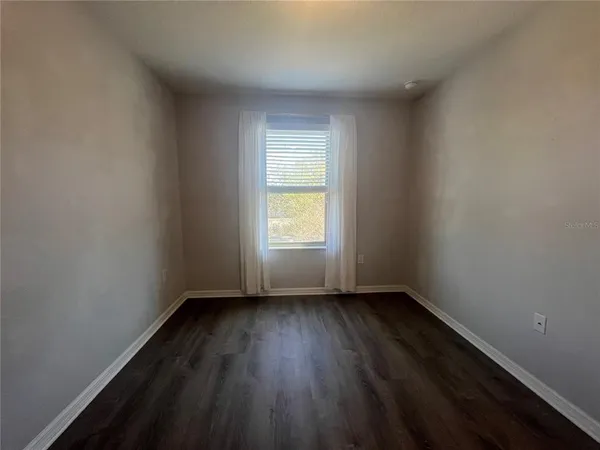 a view of an empty room and hardwood floor