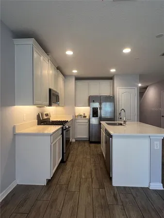 a kitchen with sink a microwave and cabinets