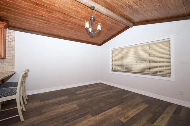 a view of a kitchen with a fridge and wooden floor