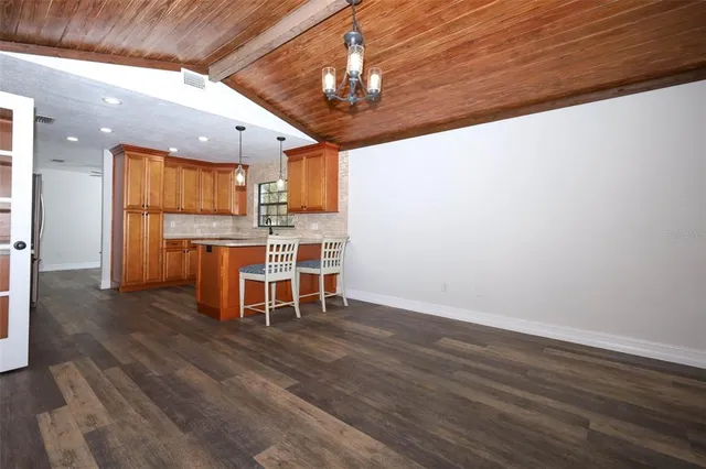 a kitchen with stainless steel appliances granite countertop a sink cabinets and wooden floor